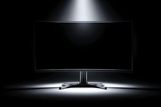 Desktop monitor illuminated against a dark studio background